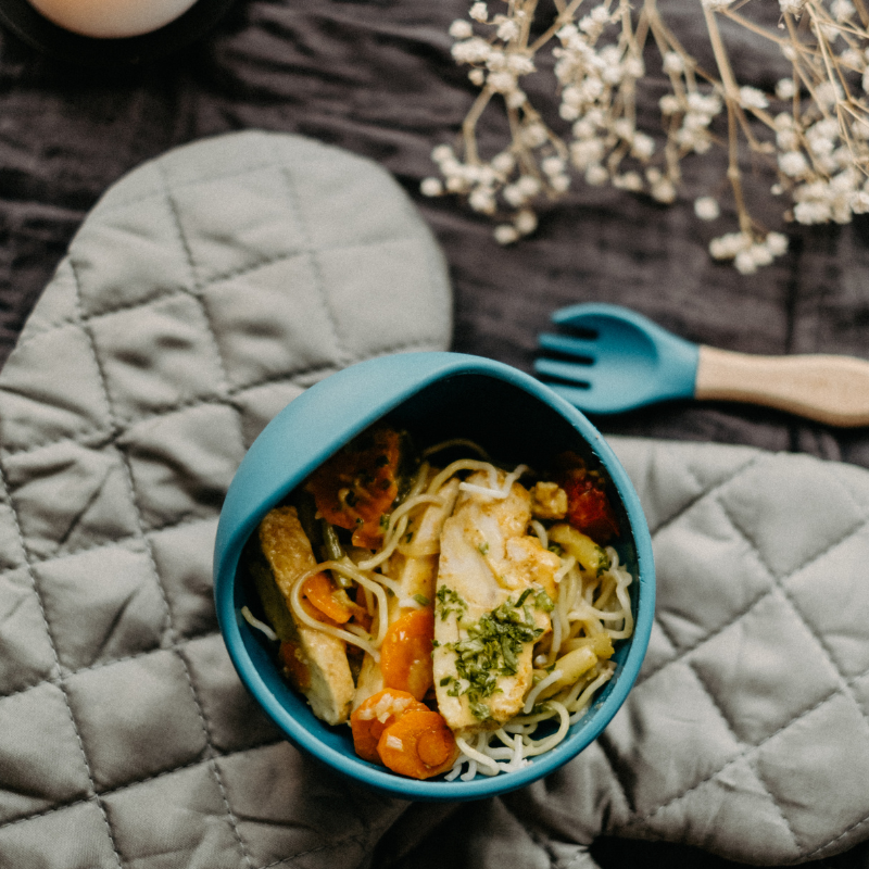 Poulet tendre, vermicelles de riz et légumes croquants dans une sauce douce au lait de coco, un repas équilibré pour enfants en garderie.