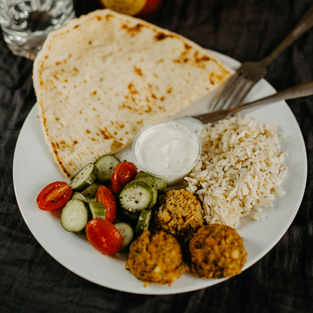 Falafels maison avec salade de couscous aux légumes, sauce tzatziki fraîche et pain naan moelleux